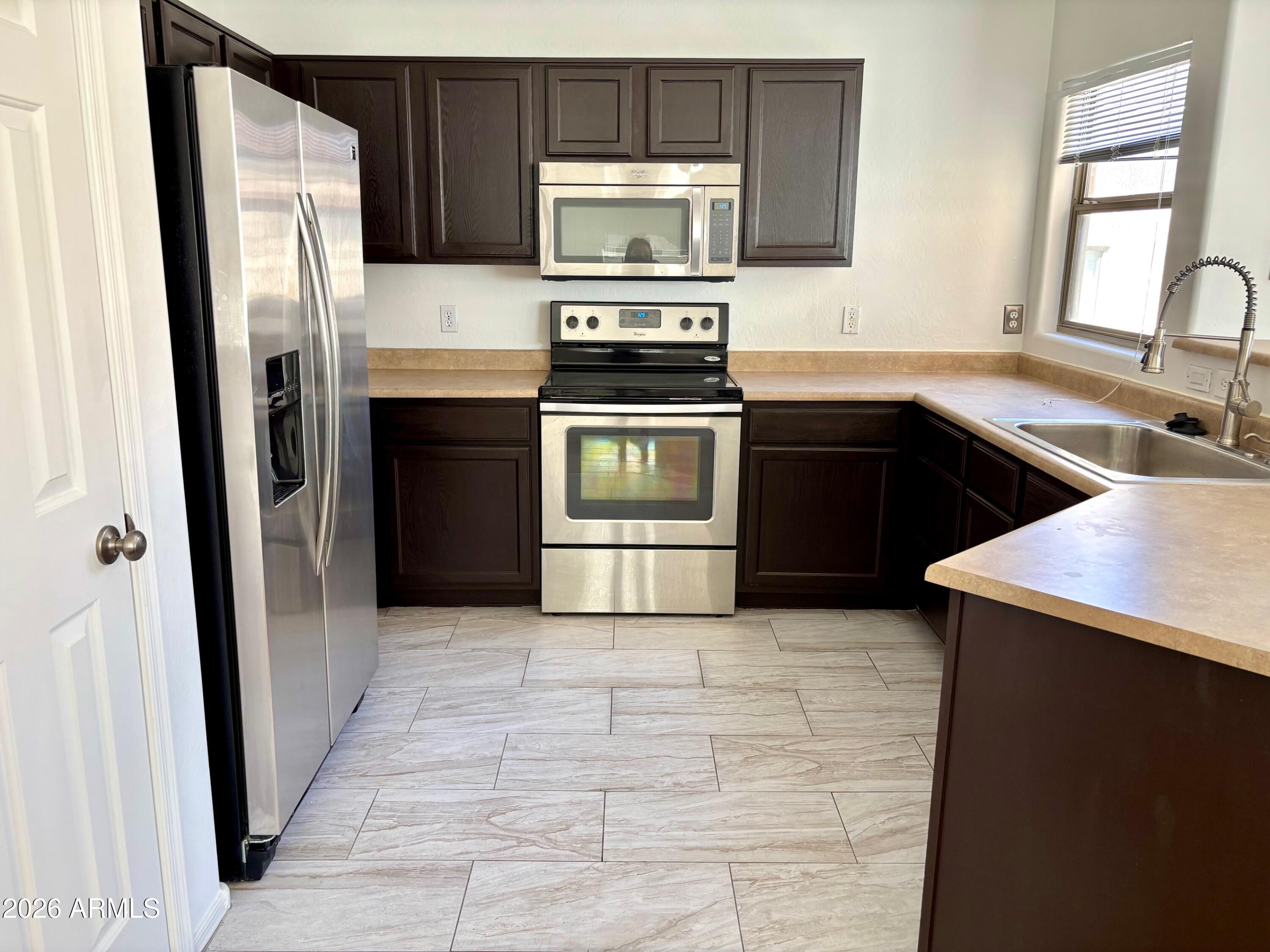 525 North Miller Road, Unit 239 Scottsdale, AZ 85257 - Photo 2 of 52 a kitchen with a refrigerator stove and sink