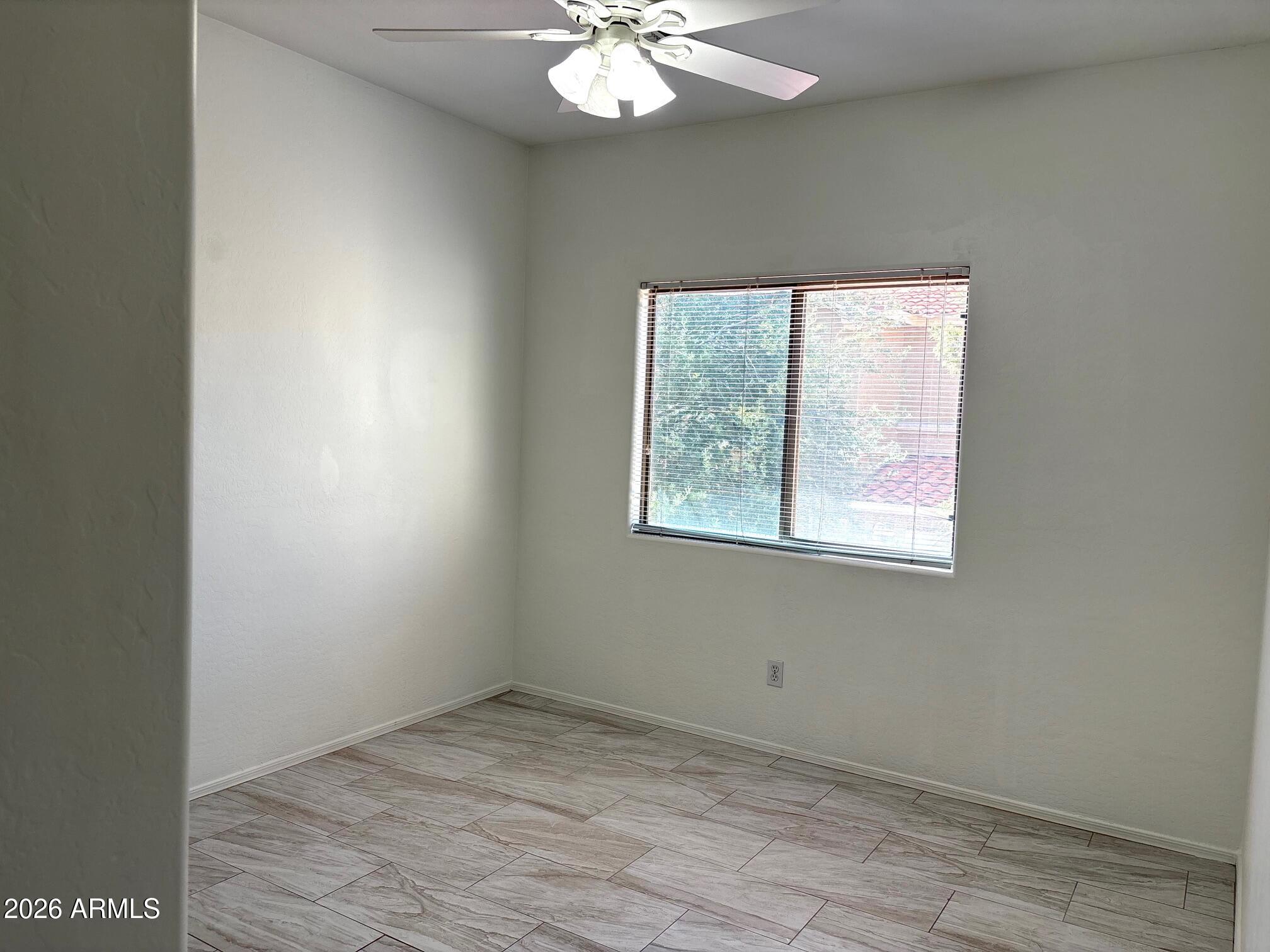 525 North Miller Road, Unit 239 Scottsdale, AZ 85257 - Photo 30 of 52 an empty room with a chandelier fan and windows