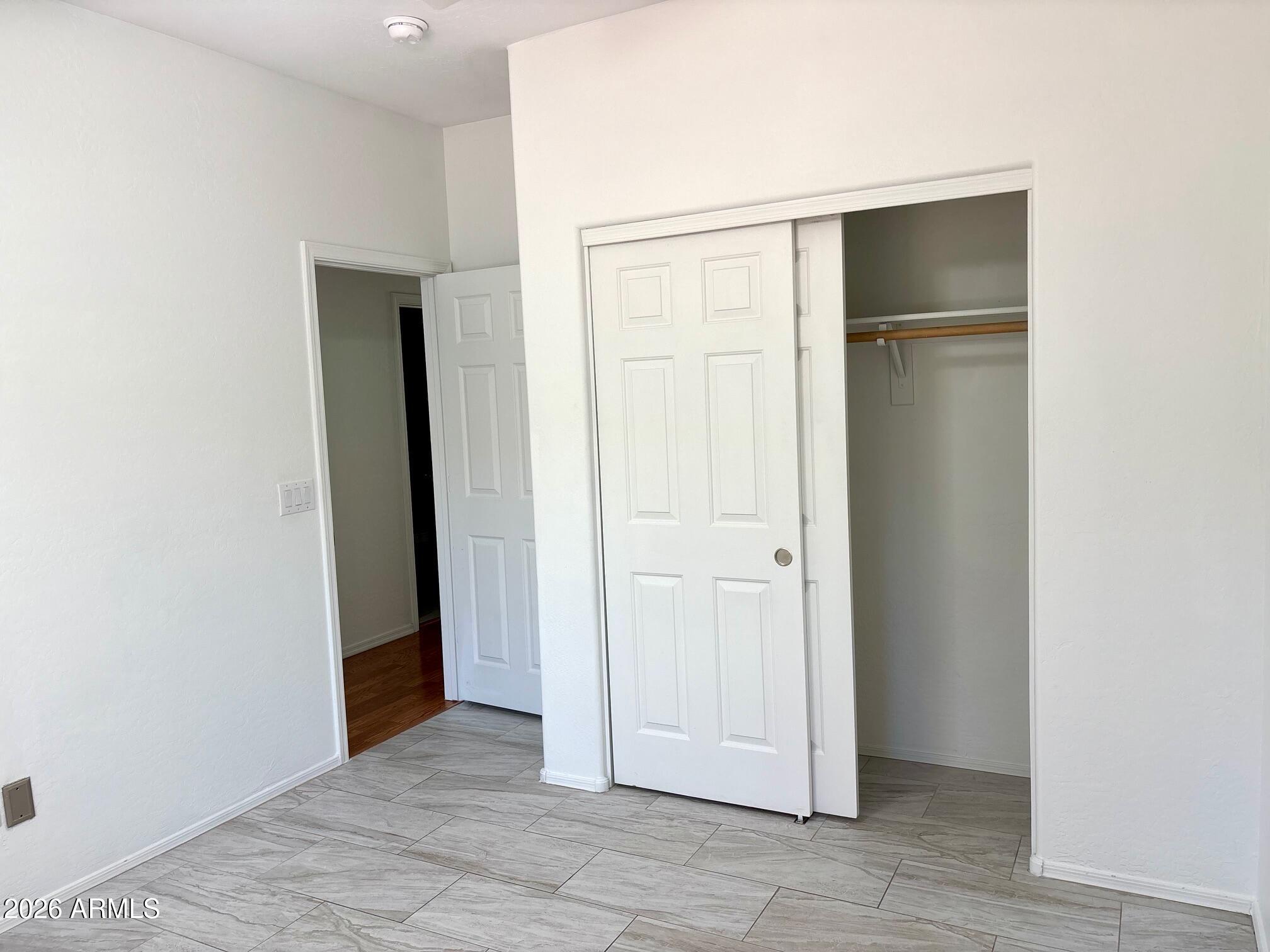 525 North Miller Road, Unit 239 Scottsdale, AZ 85257 - Photo 32 of 52 an empty room with closet and wooden floor