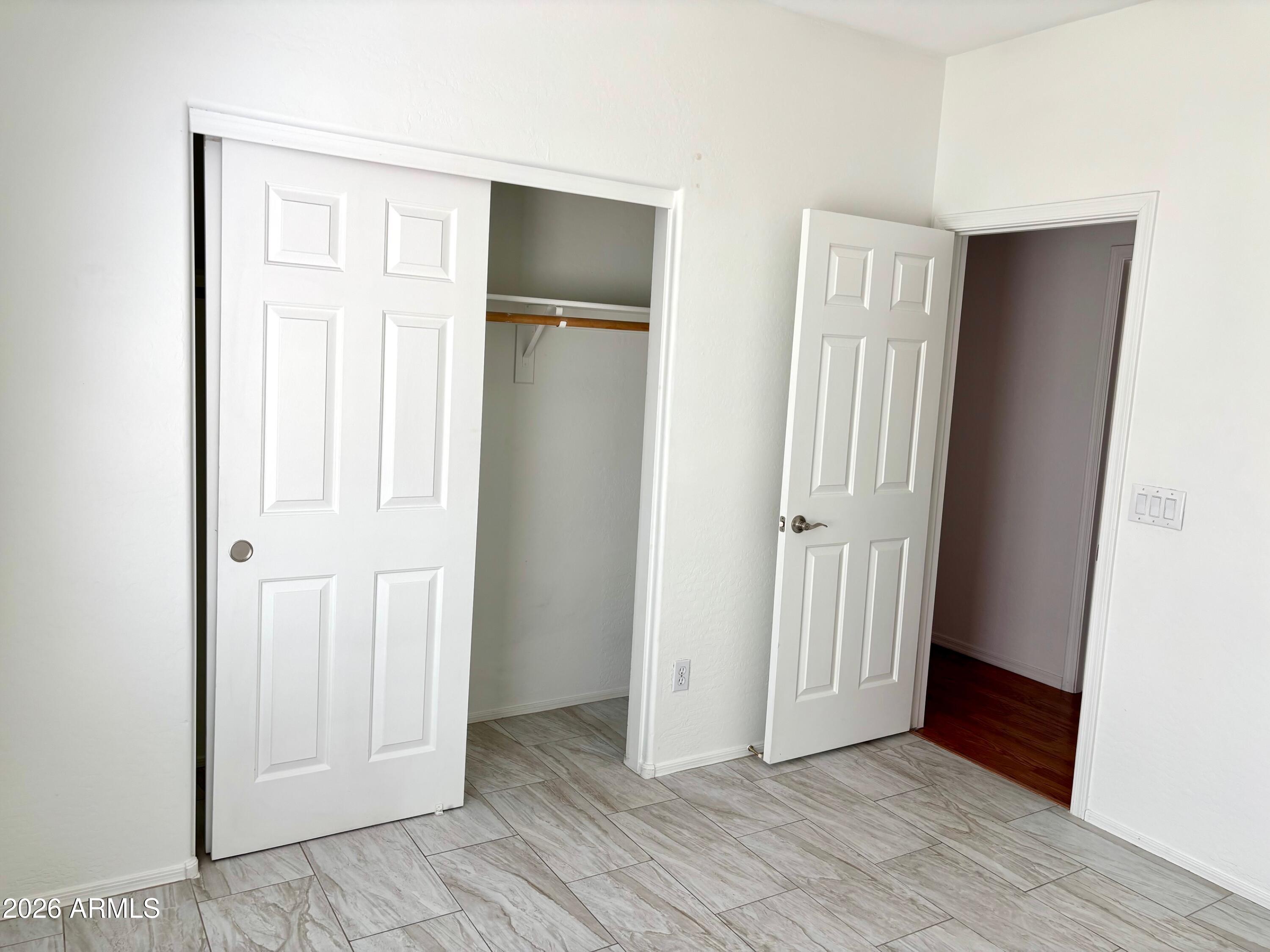 525 North Miller Road, Unit 239 Scottsdale, AZ 85257 - Photo 36 of 52 an empty room with wooden floor and closet area
