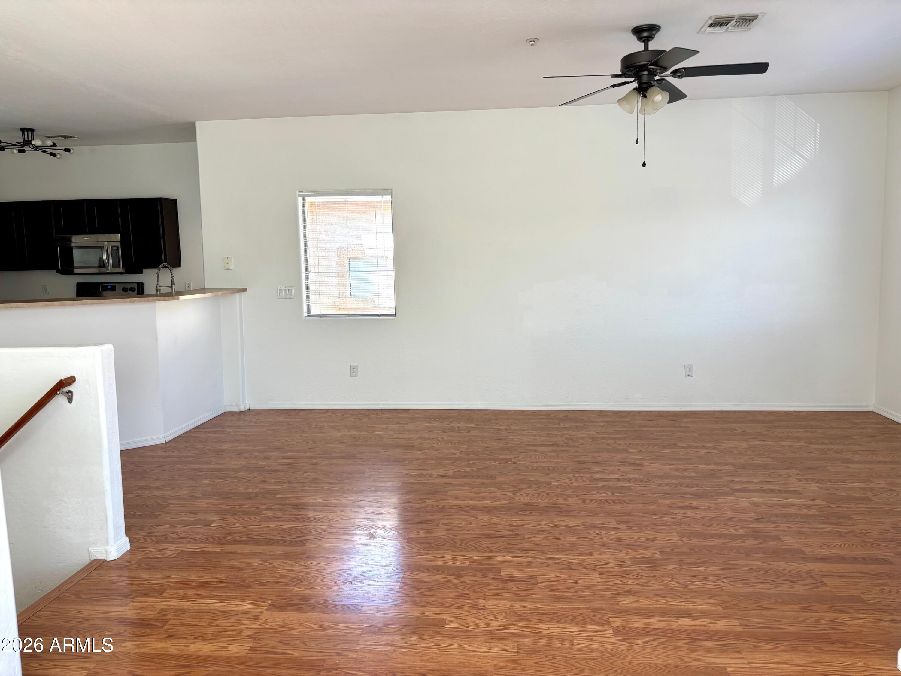 525 North Miller Road, Unit 239 Scottsdale, AZ 85257 - Photo 10 of 52 a view of a room with wooden floor and a ceiling fan