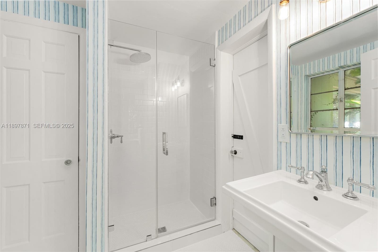 5950 Southwest 128th Street Pinecrest, FL 33156 - Photo 15 of 37 a bathroom with a sink a mirror and a shower