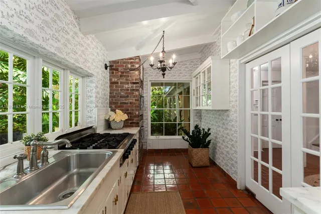 a kitchen with stainless steel appliances a stove a sink and a white wooden cabinets