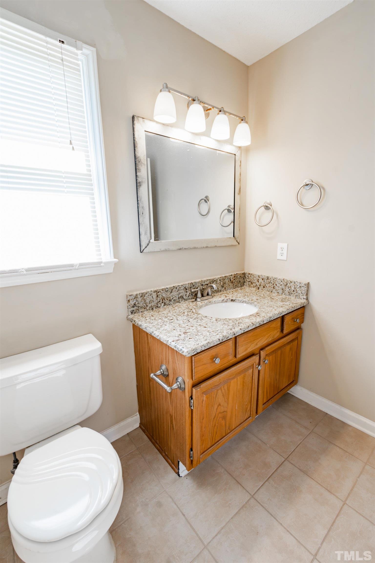 99 Windsor Drive Angier, NC 27501 - Photo 13 of 21 a bathroom with a granite countertop sink a toilet and mirror