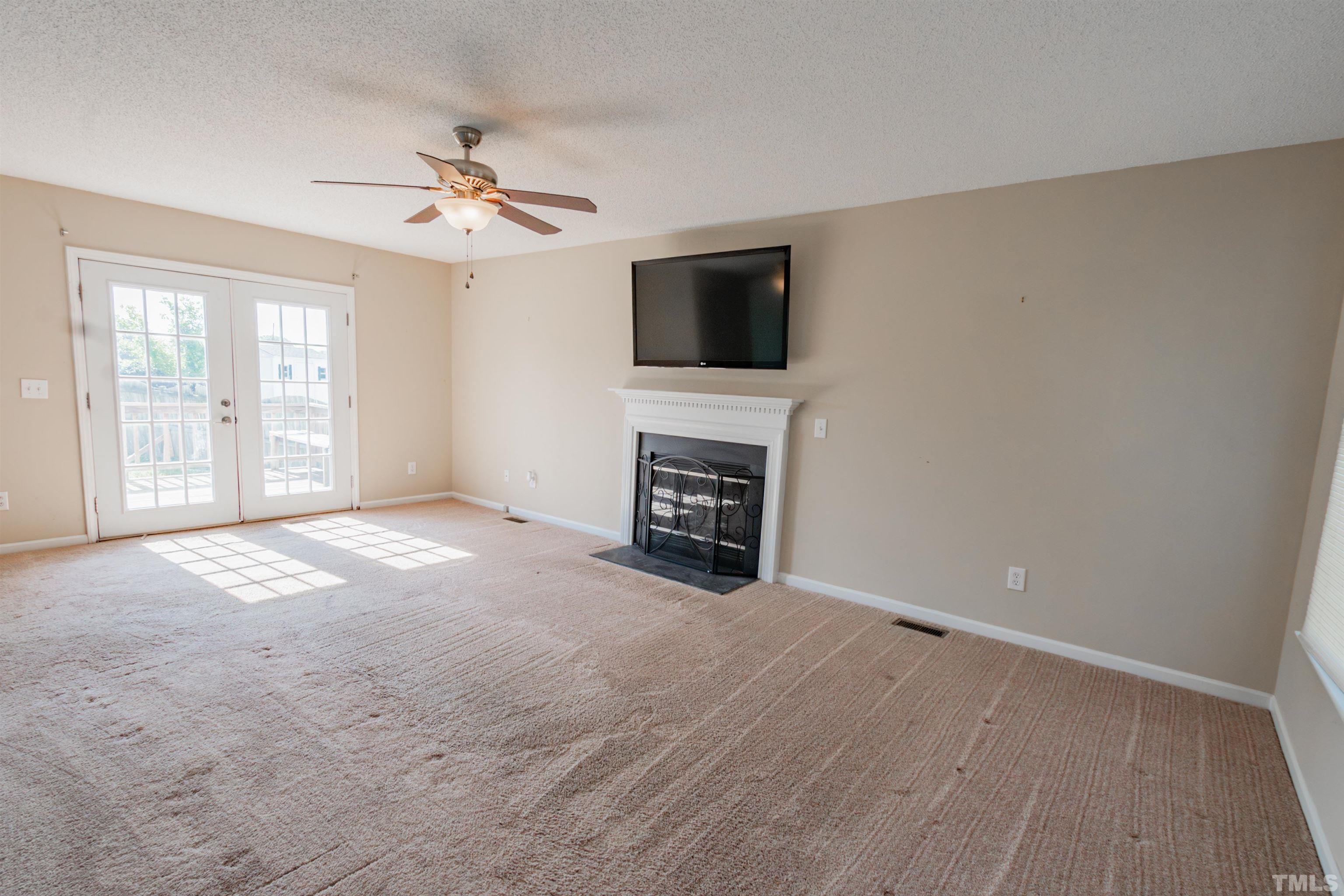 99 Windsor Drive Angier, NC 27501 - Photo 3 of 21 a view of a livingroom with a flat screen tv ceiling fan and a fireplace