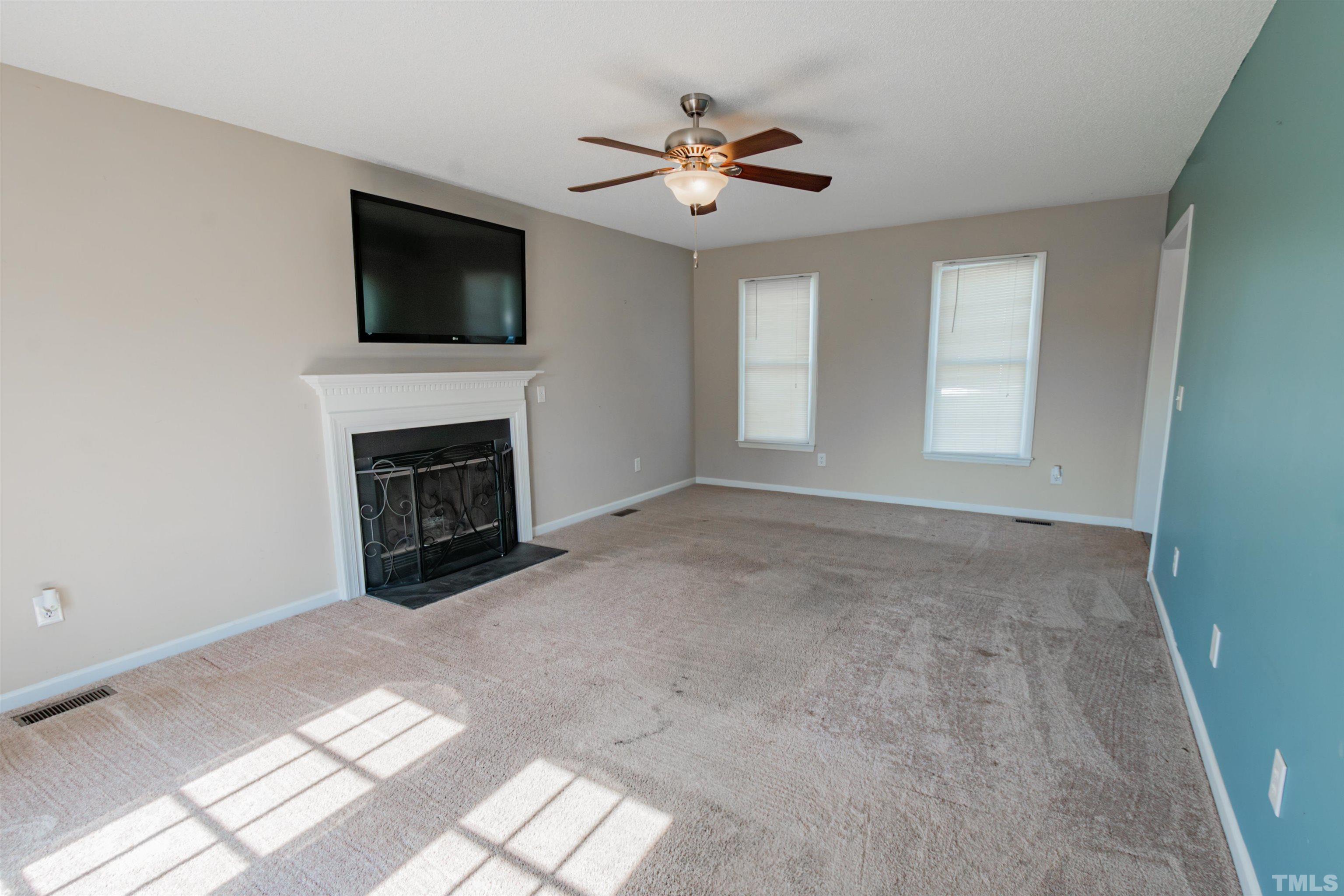 99 Windsor Drive Angier, NC 27501 - Photo 5 of 21 a view of empty room with fireplace and fan