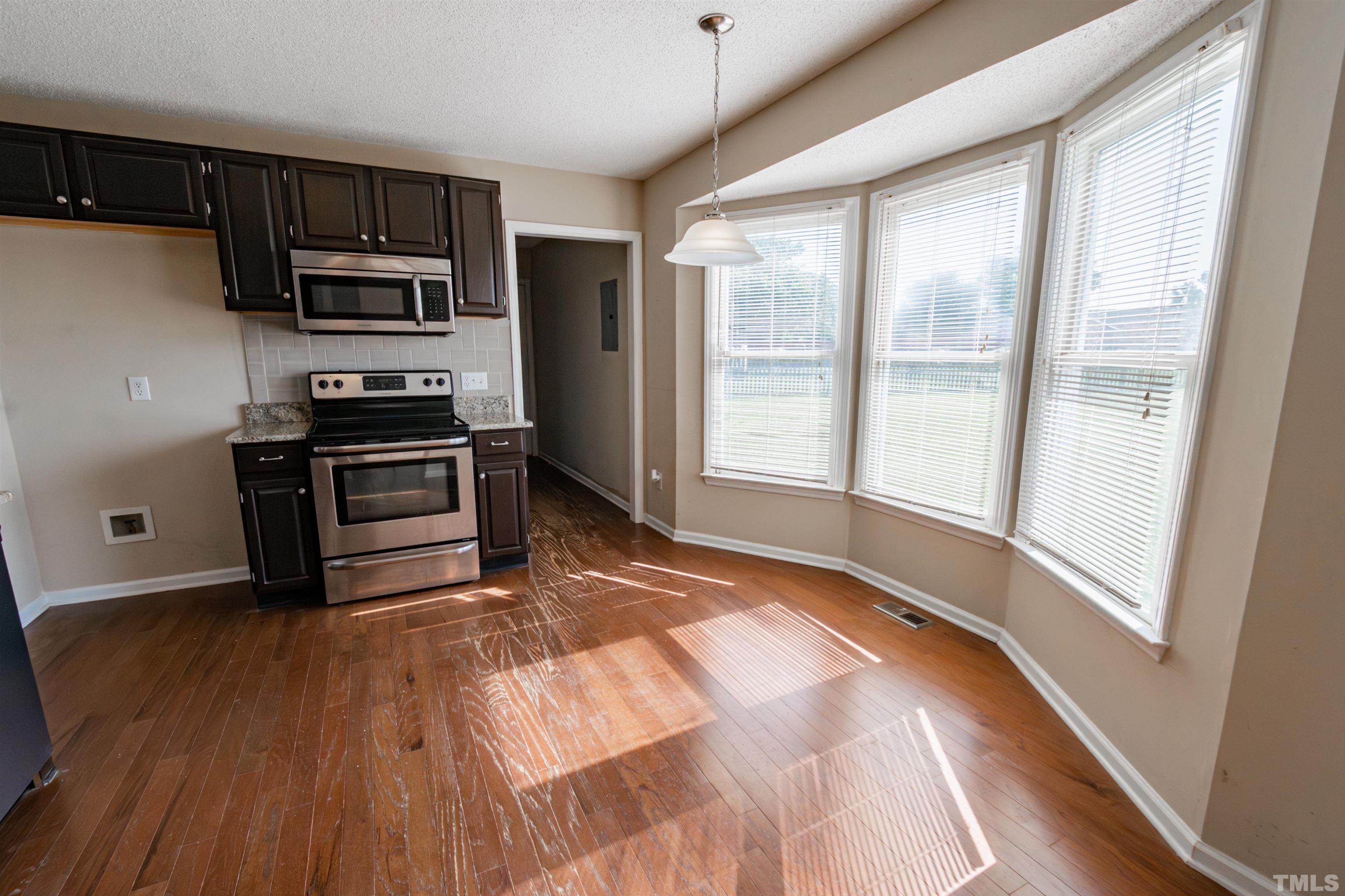 99 Windsor Drive Angier, NC 27501 - Photo 6 of 21 a kitchen with stainless steel appliances granite countertop a stove a sink and a refrigerator