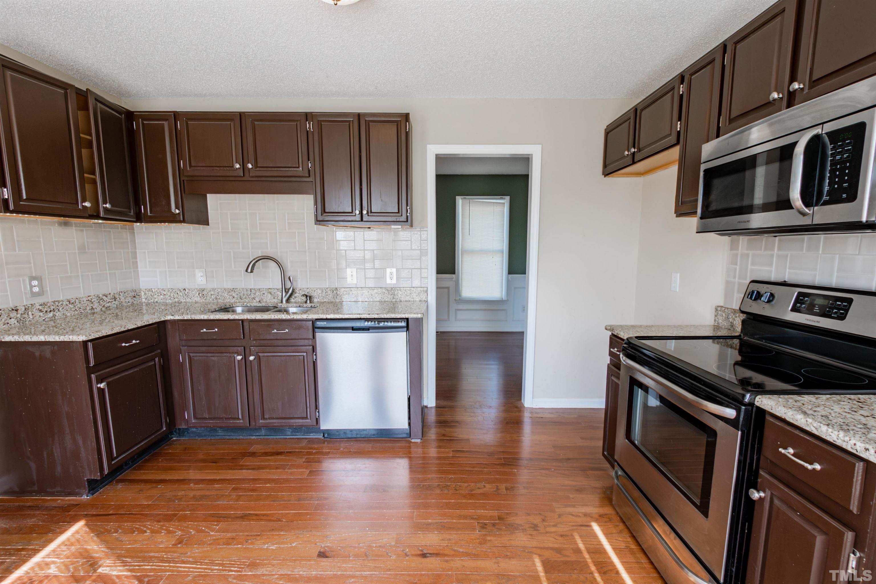 99 Windsor Drive Angier, NC 27501 - Photo 7 of 21 a kitchen with stainless steel appliances granite countertop a stove a sink and a microwave