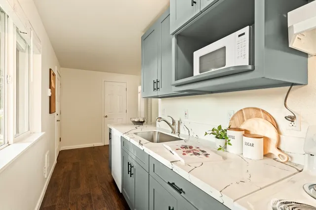 a kitchen with a sink and a wooden floor