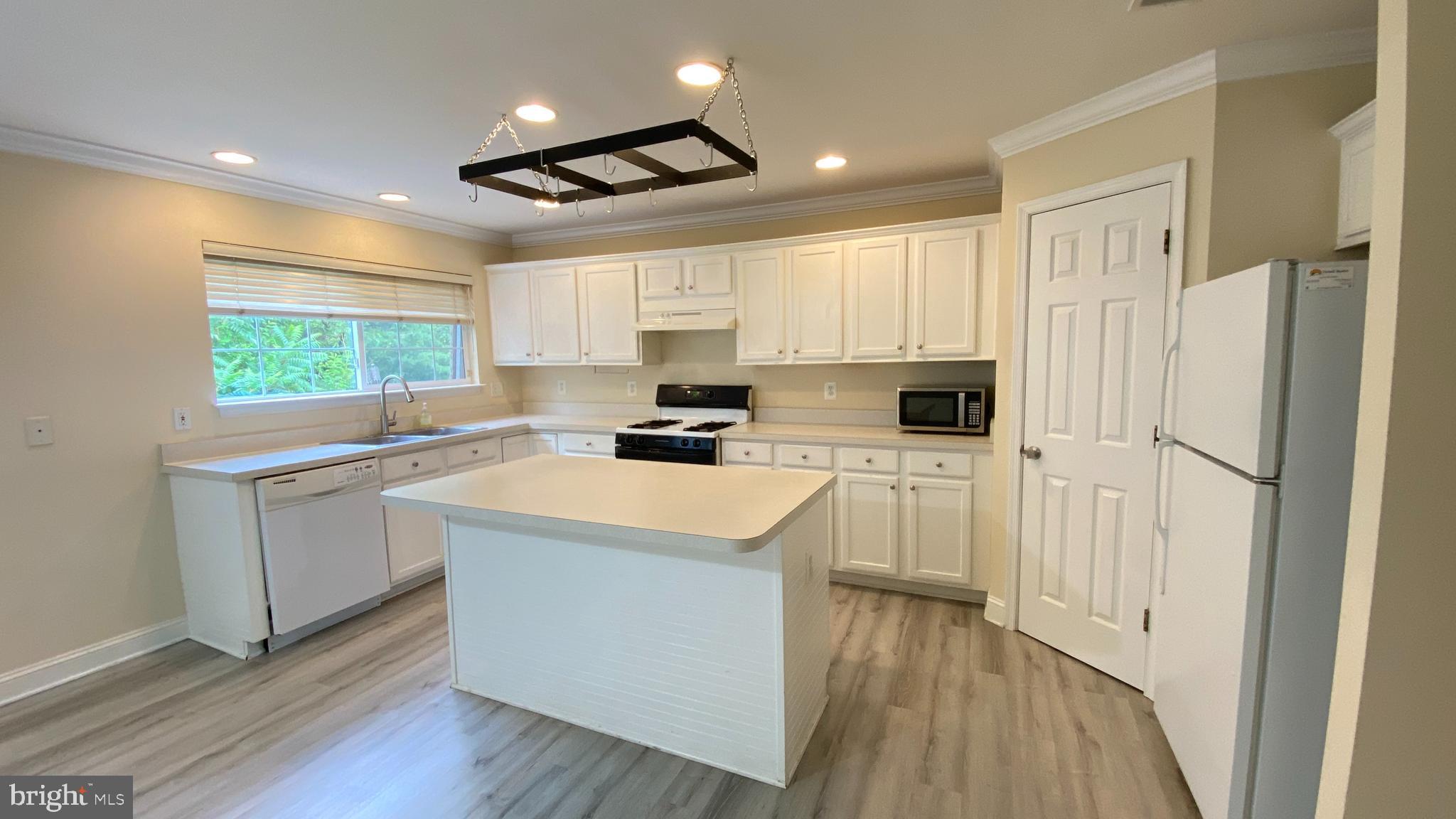 8231 Ramseur Place Manassas, VA 20109 - Photo 3 of 16 a kitchen with white cabinets and white appliances