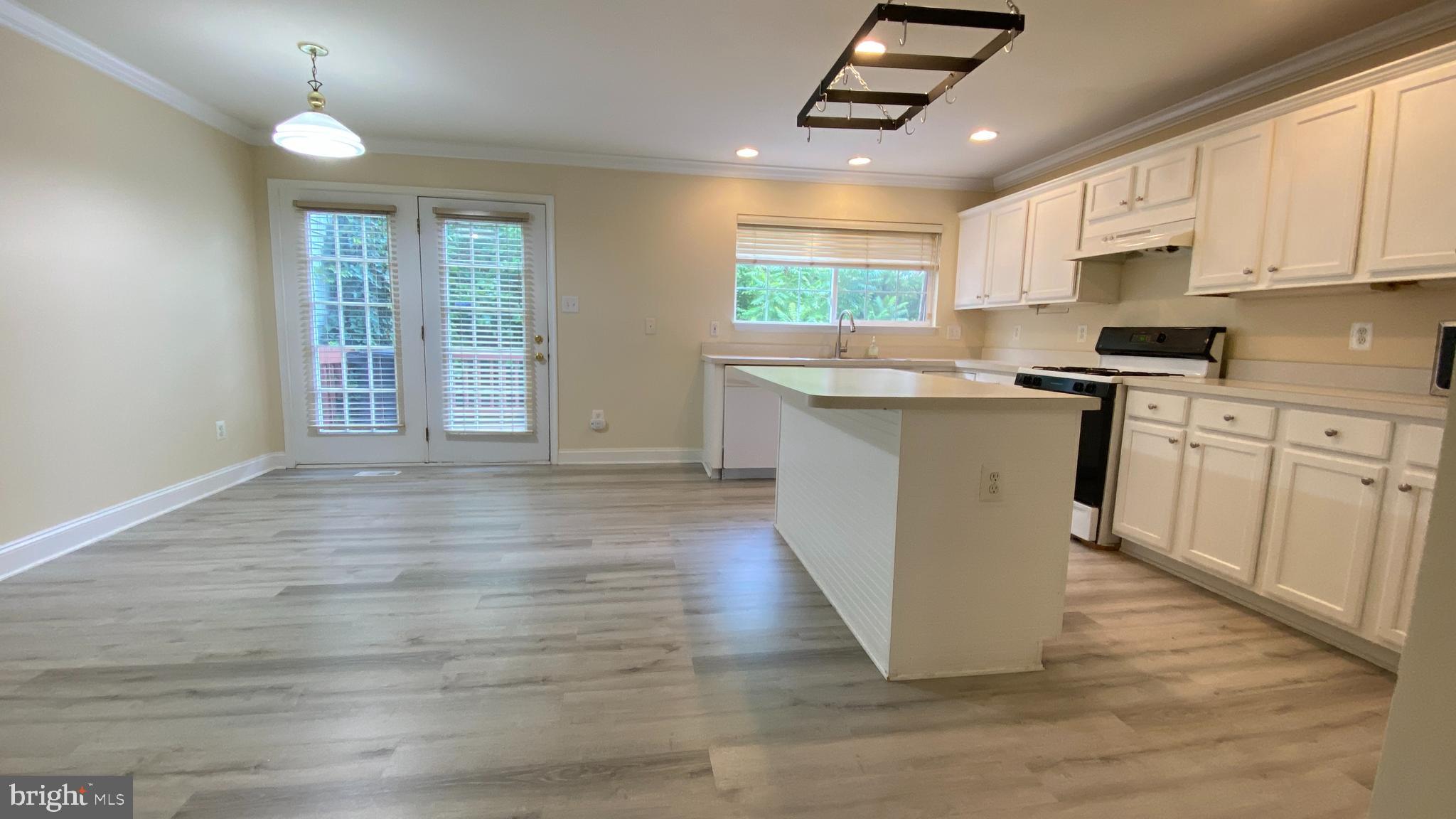 8231 Ramseur Place Manassas, VA 20109 - Photo 4 of 16 a kitchen with stainless steel appliances granite countertop wooden floors and white cabinets