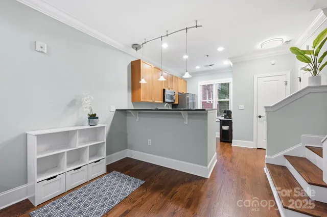 a kitchen with stainless steel appliances refrigerator wooden floor dining table and chairs