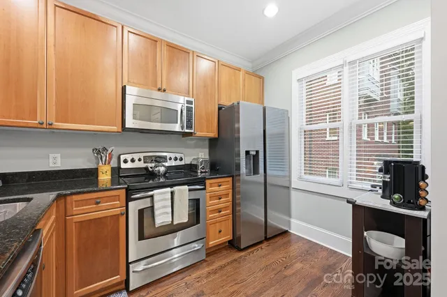 a kitchen with stainless steel appliances granite countertop a stove a sink and a microwave