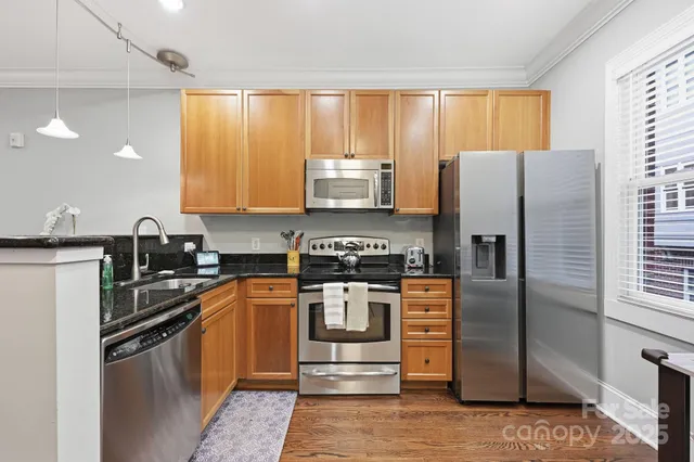 a kitchen with stainless steel appliances granite countertop a stove a refrigerator and a sink