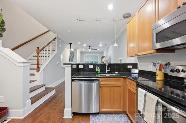 a kitchen with stainless steel appliances granite countertop a sink a stove and a refrigerator