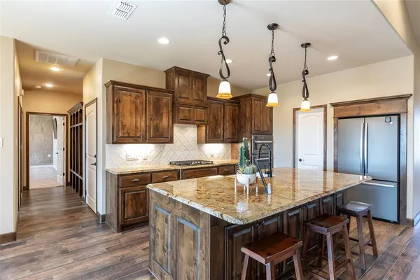 a kitchen with stainless steel appliances granite countertop a kitchen island a stove and a sink
