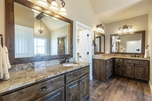 a bathroom with a granite countertop double vanity sink and a mirror