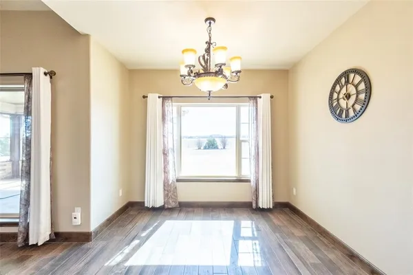 a view of a hallway with wooden floor and a large window