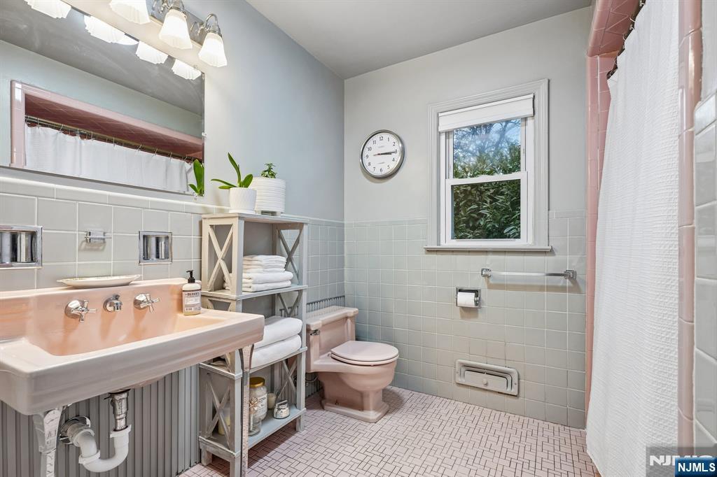 398 Grove Street Montclair, NJ 07043 - Photo 20 of 48 a spacious bathroom with a sink a toilet a mirror and a window