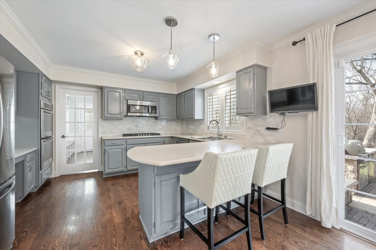 1588 White Oak Road Lake Forest, IL 60045 - Photo 9 of 35 a kitchen with stainless steel appliances a white table chairs refrigerator and sink