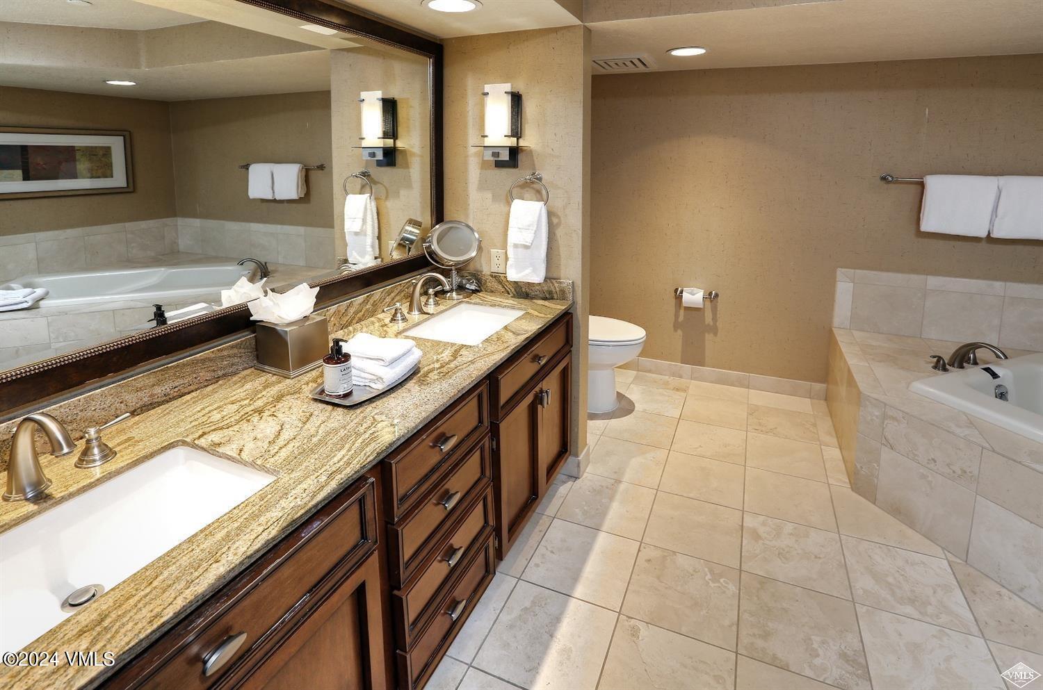 210 Offerson Road, Unit 1085 Beaver Creek, CO 81620 - Photo 7 of 10 a spacious bathroom with a granite countertop sink and a mirror