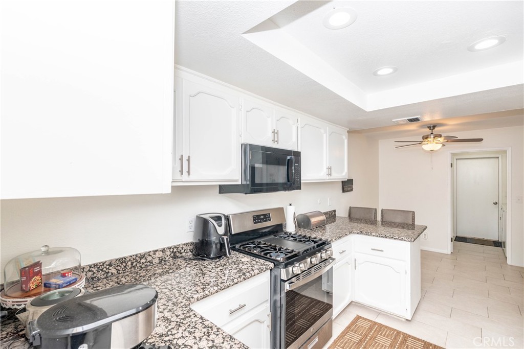 11520 Los Molinos Way Riverside, CA 92505 - Photo 11 of 26 a kitchen with a stove and a white cabinets