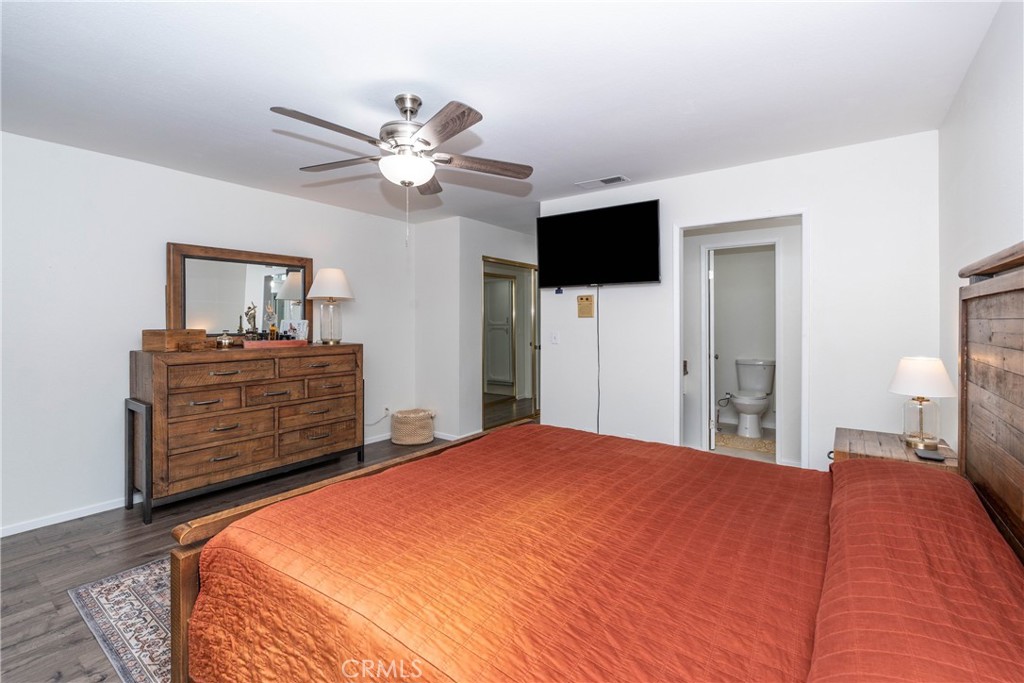 11520 Los Molinos Way Riverside, CA 92505 - Photo 18 of 26 a bedroom with a bed a dresser and a chandelier