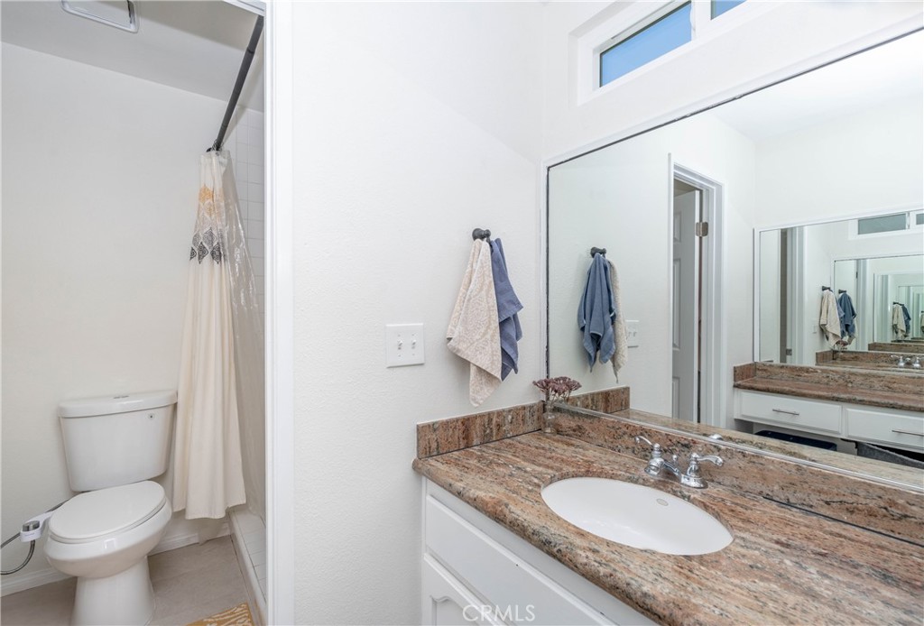 11520 Los Molinos Way Riverside, CA 92505 - Photo 21 of 26 a bathroom with a granite countertop sink toilet and a mirror