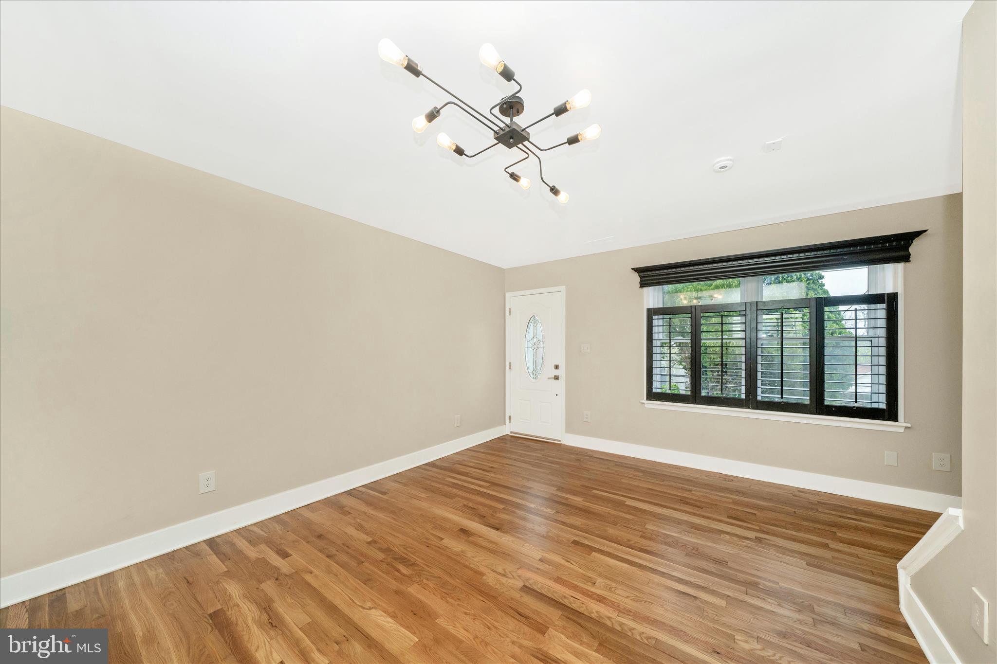 5045 Sheriff Road Northeast Washington, DC 20019 - Photo 4 of 38 an empty room with wooden floor fan and windows