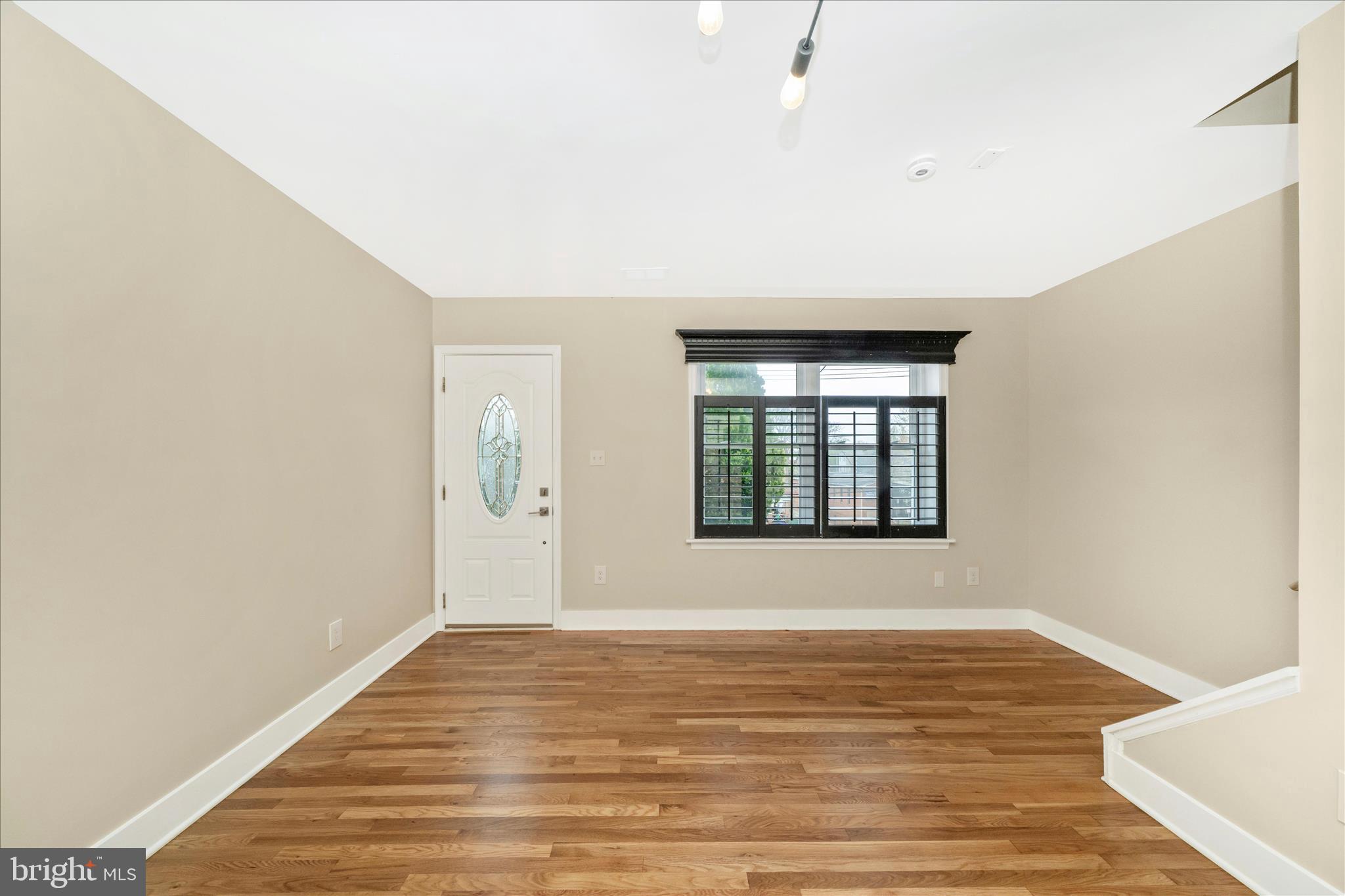 5045 Sheriff Road Northeast Washington, DC 20019 - Photo 5 of 38 a view of an empty room with wooden floor and a window