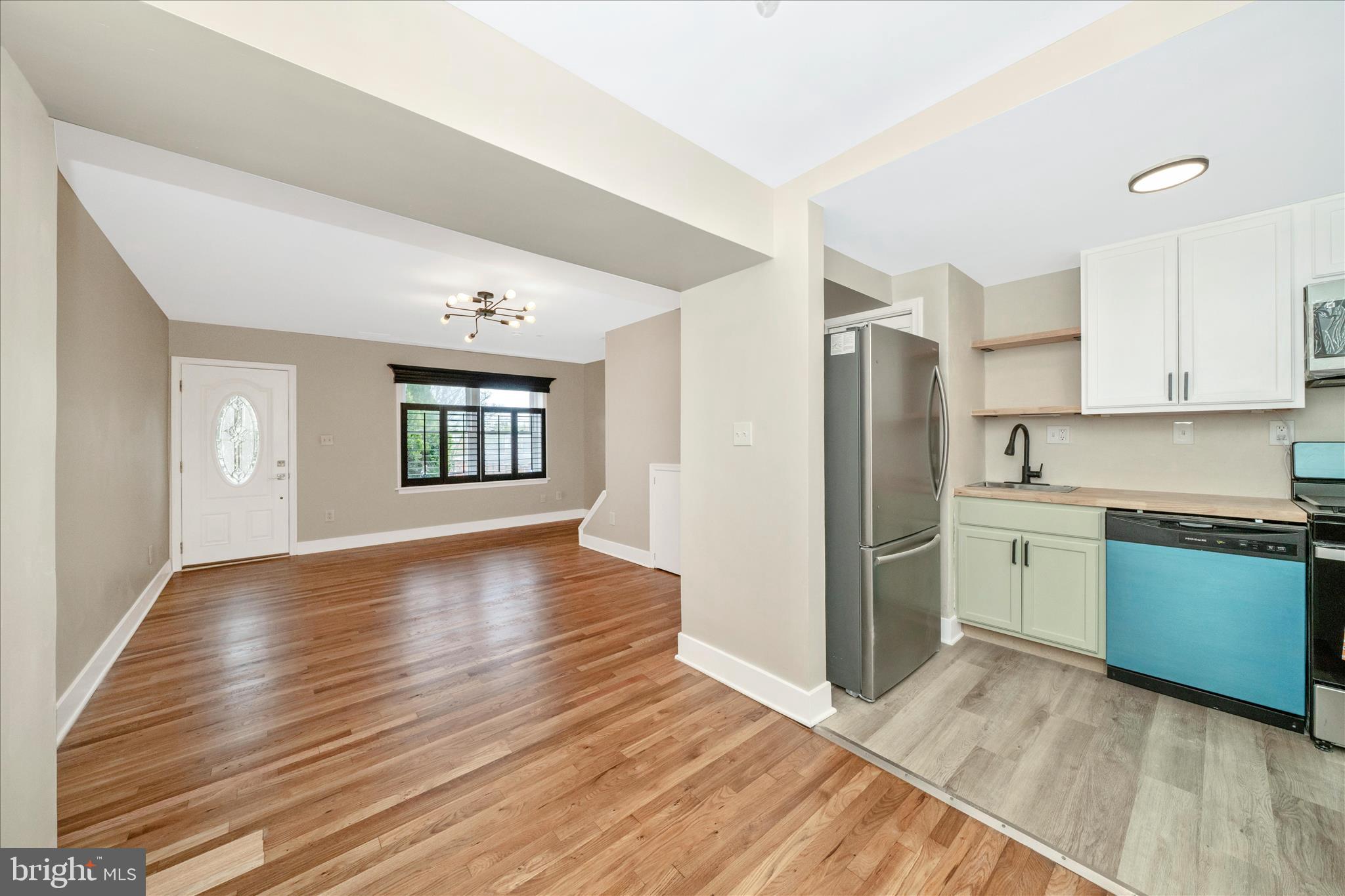 5045 Sheriff Road Northeast Washington, DC 20019 - Photo 7 of 38 a view of a kitchen with a fridge wooden floor and a sink