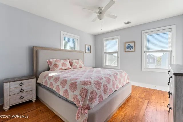 a bedroom with a large bed a flat tv screen and a window
