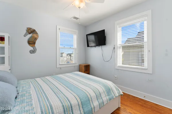 a view of a livingroom with wooden floor and a flat screen tv