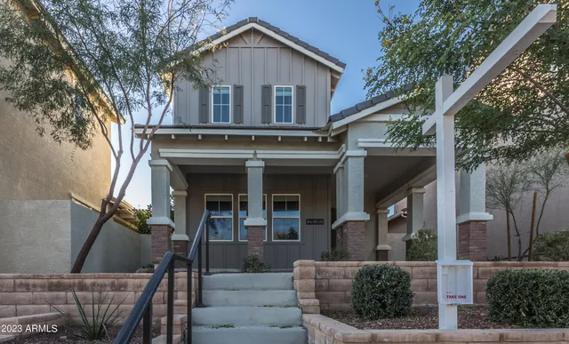 a front view of a house with glass windows and a tree