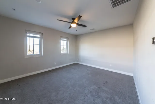 an empty room with windows and ceiling fan view