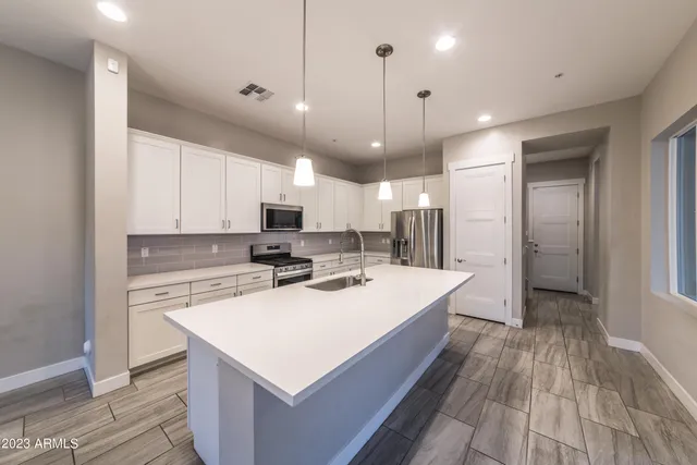 a kitchen with a sink a counter top stainless steel appliances and cabinets