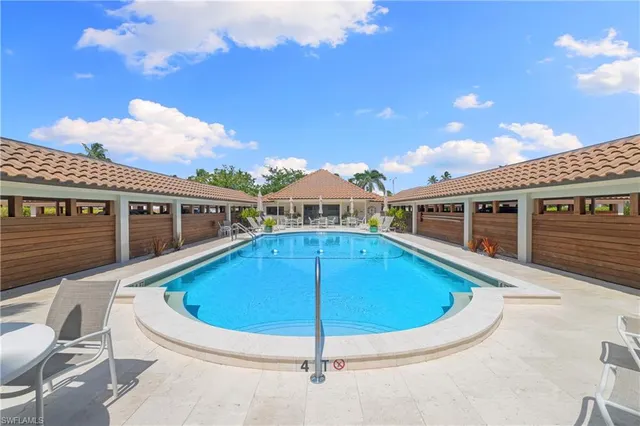 a blue swimming pool with view of a house