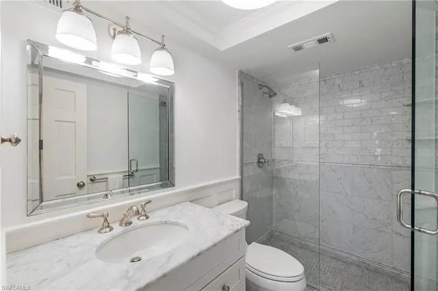 a bathroom with a sink vanity granite toilet and shower