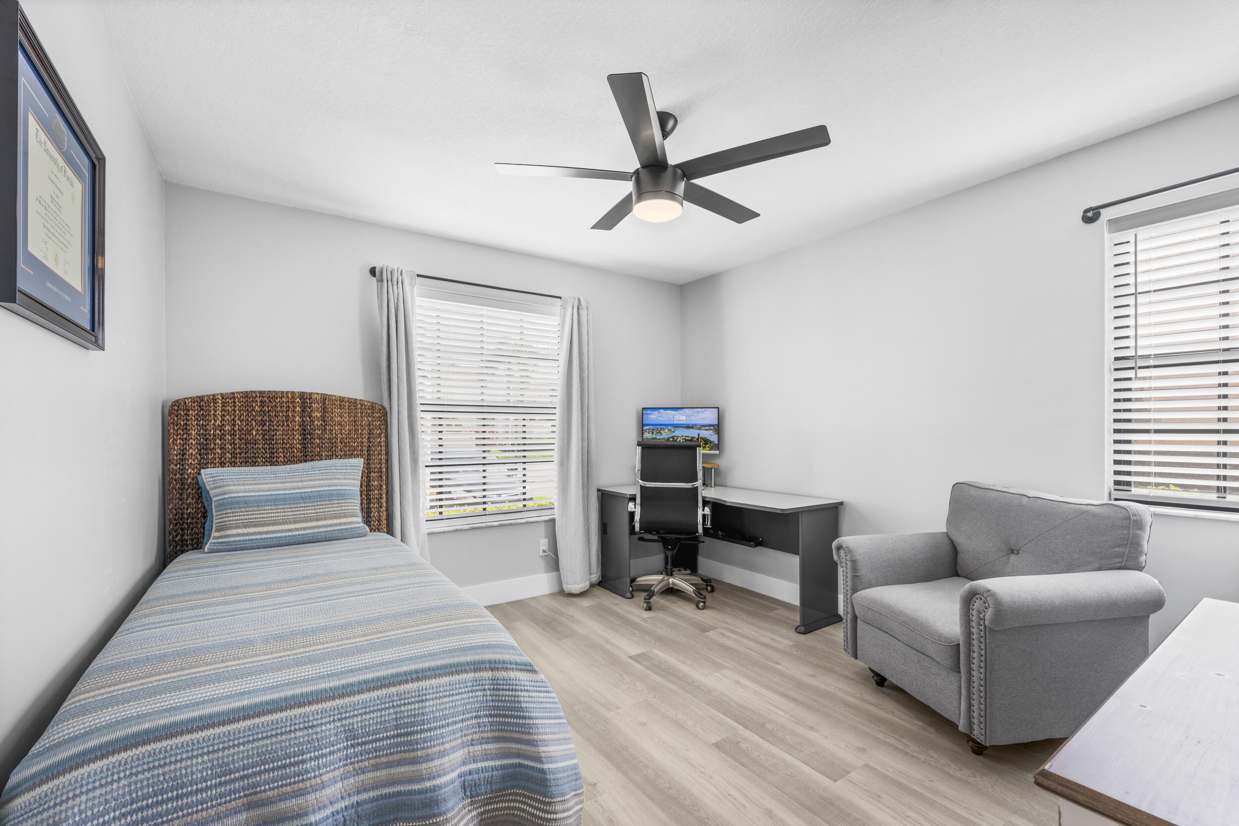 17867 Thelma Avenue, Unit A Jupiter, FL 33458 - Photo 15 of 35 a bedroom with a bed a couch and a window