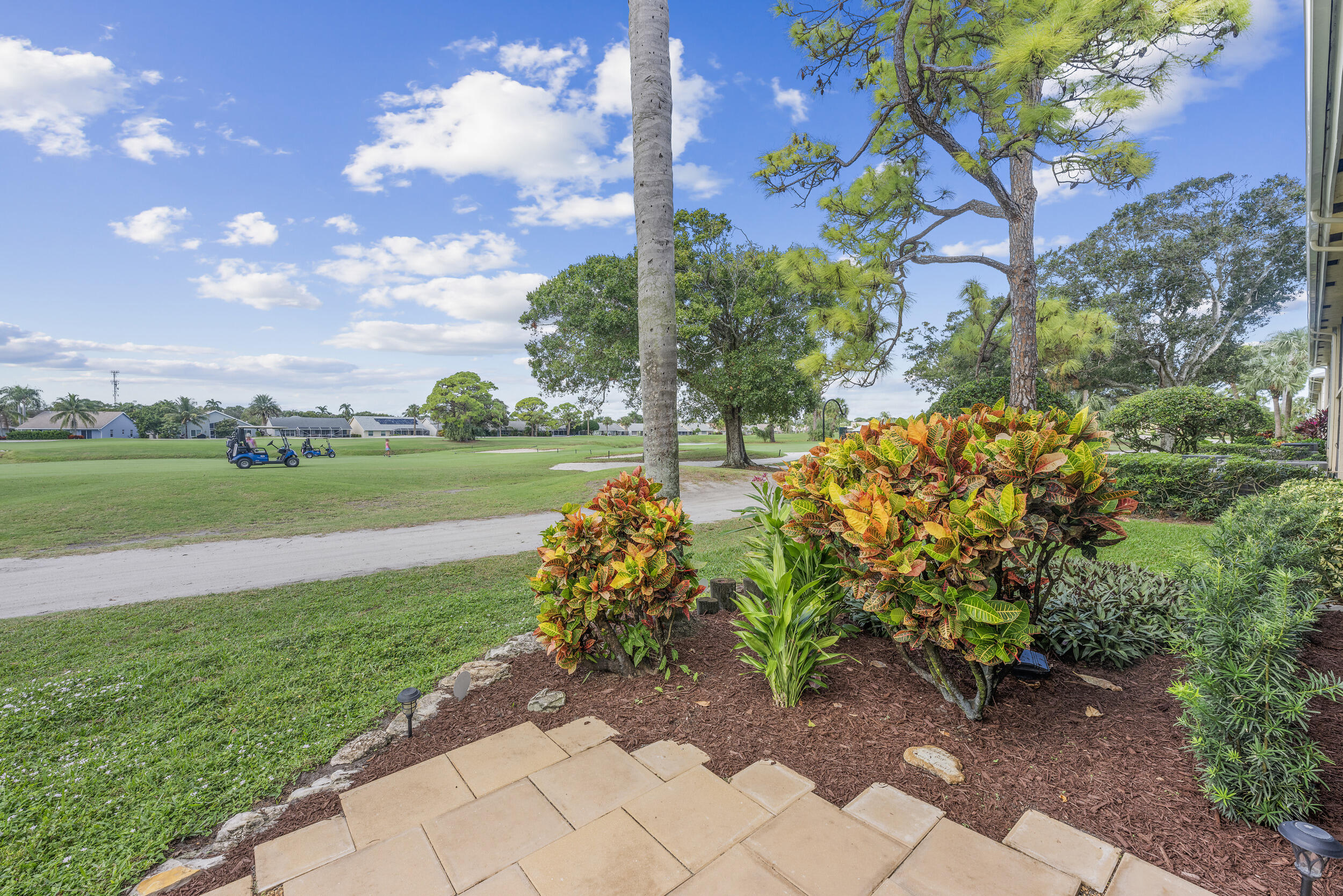 17867 Thelma Avenue, Unit A Jupiter, FL 33458 - Photo 24 of 35 a view of a garden with a building in the background