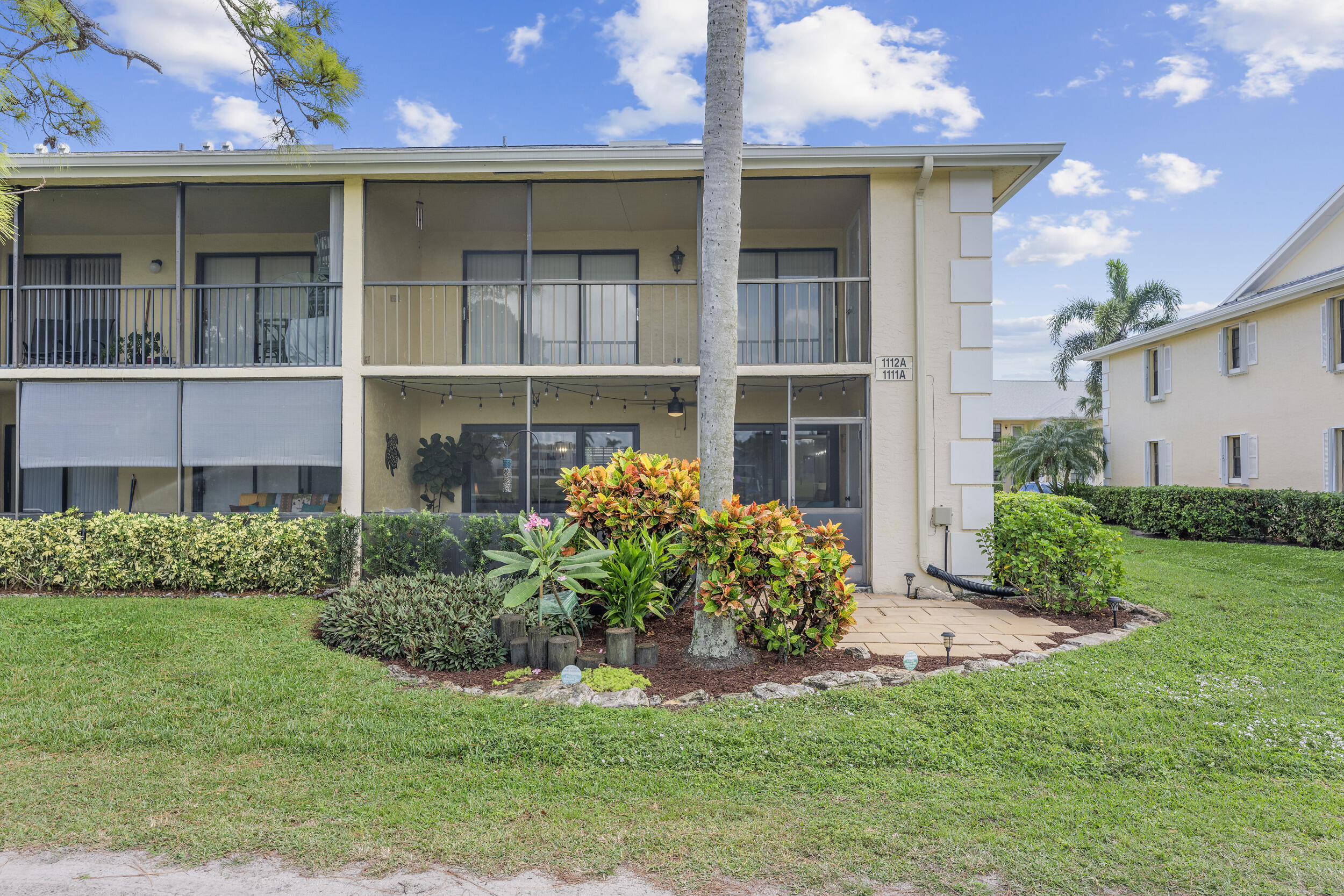 17867 Thelma Avenue, Unit A Jupiter, FL 33458 - Photo 25 of 35 a front view of a house with a yard and plants