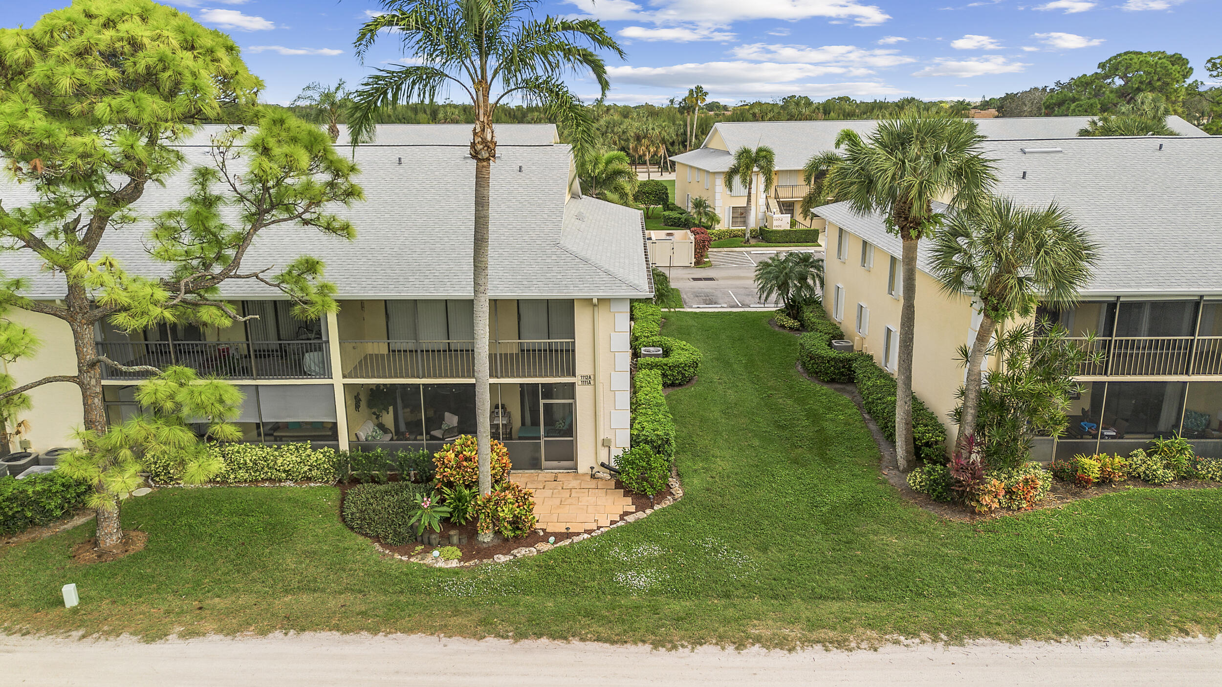 17867 Thelma Avenue, Unit A Jupiter, FL 33458 - Photo 30 of 35 a view of a white house with a big yard and potted plants