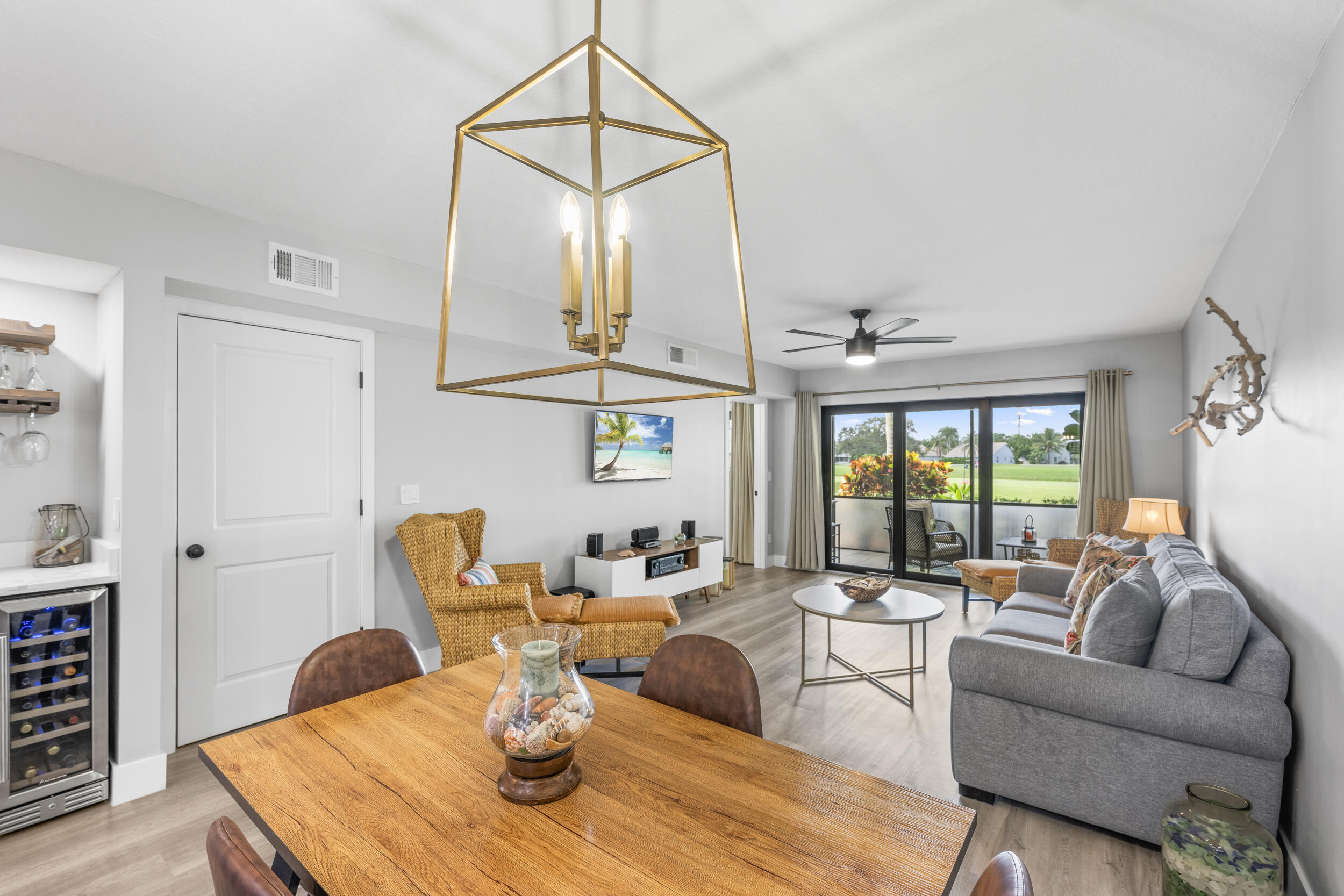 17867 Thelma Avenue, Unit A Jupiter, FL 33458 - Photo 5 of 35 a living room with furniture a fireplace and a chandelier