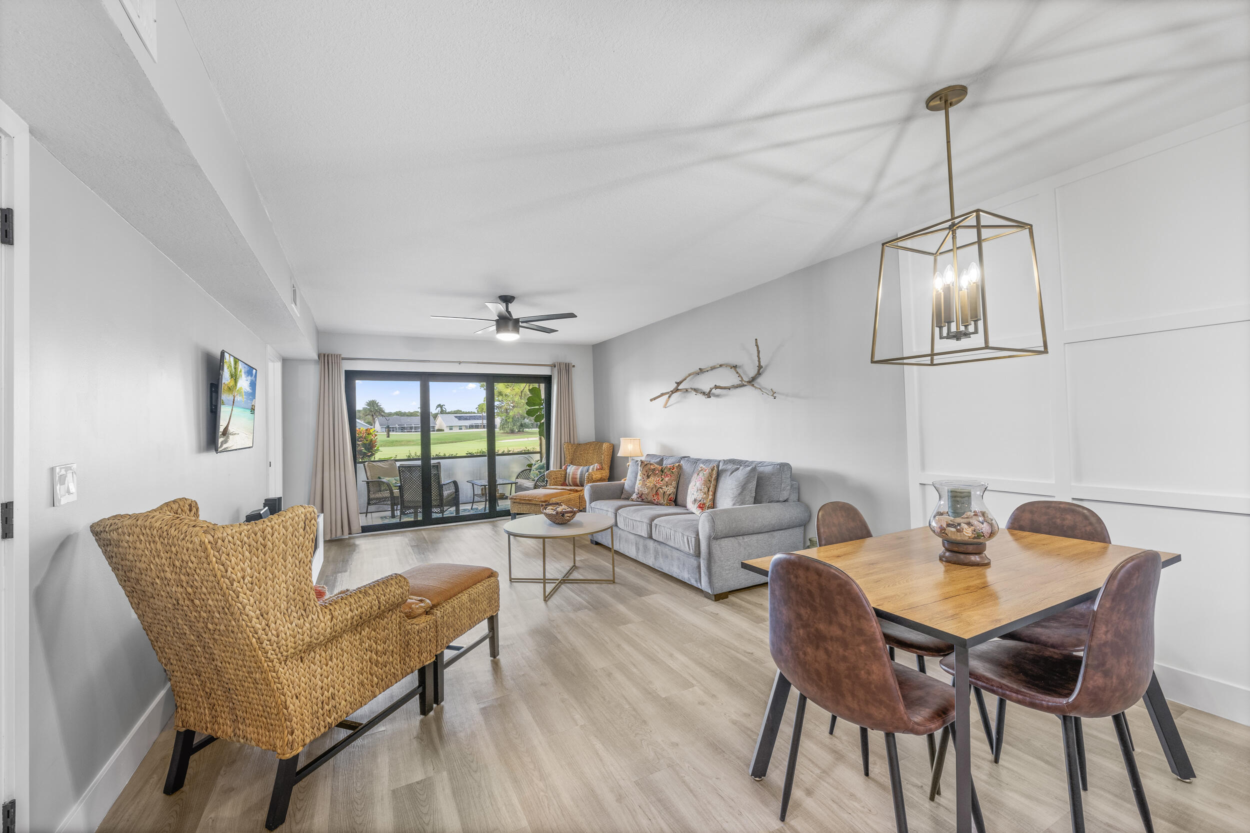 17867 Thelma Avenue, Unit A Jupiter, FL 33458 - Photo 6 of 35 a dining room with furniture a chandelier and wooden floor