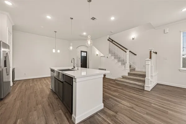 a kitchen with a sink and wooden floor