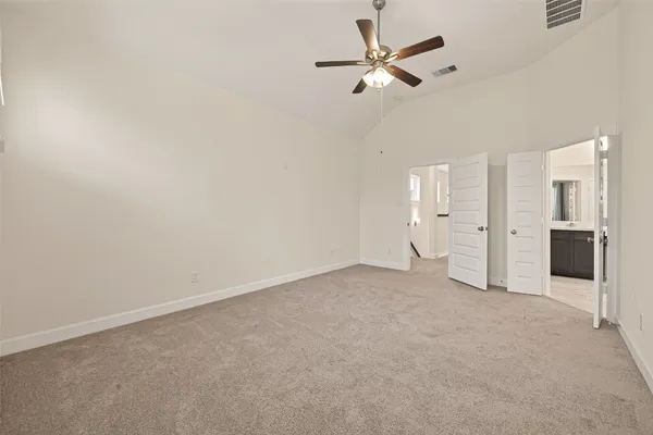 an empty room with windows and fan