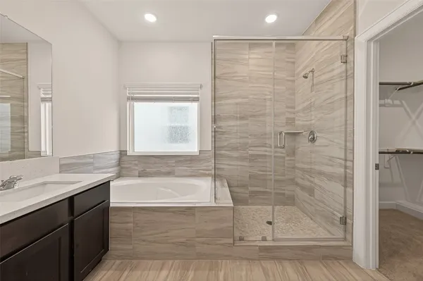 a bathroom with a tub a sink and a shower