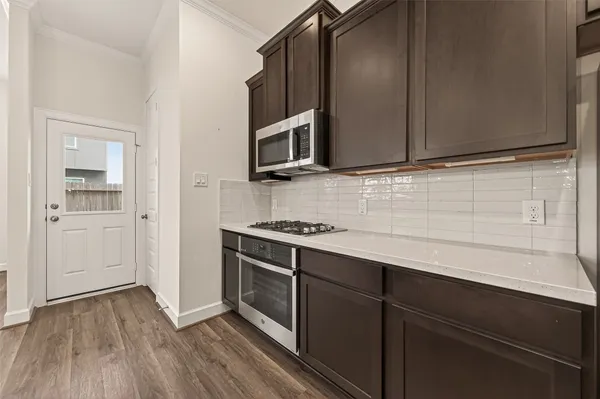 a kitchen with stainless steel appliances a stove microwave and cabinets