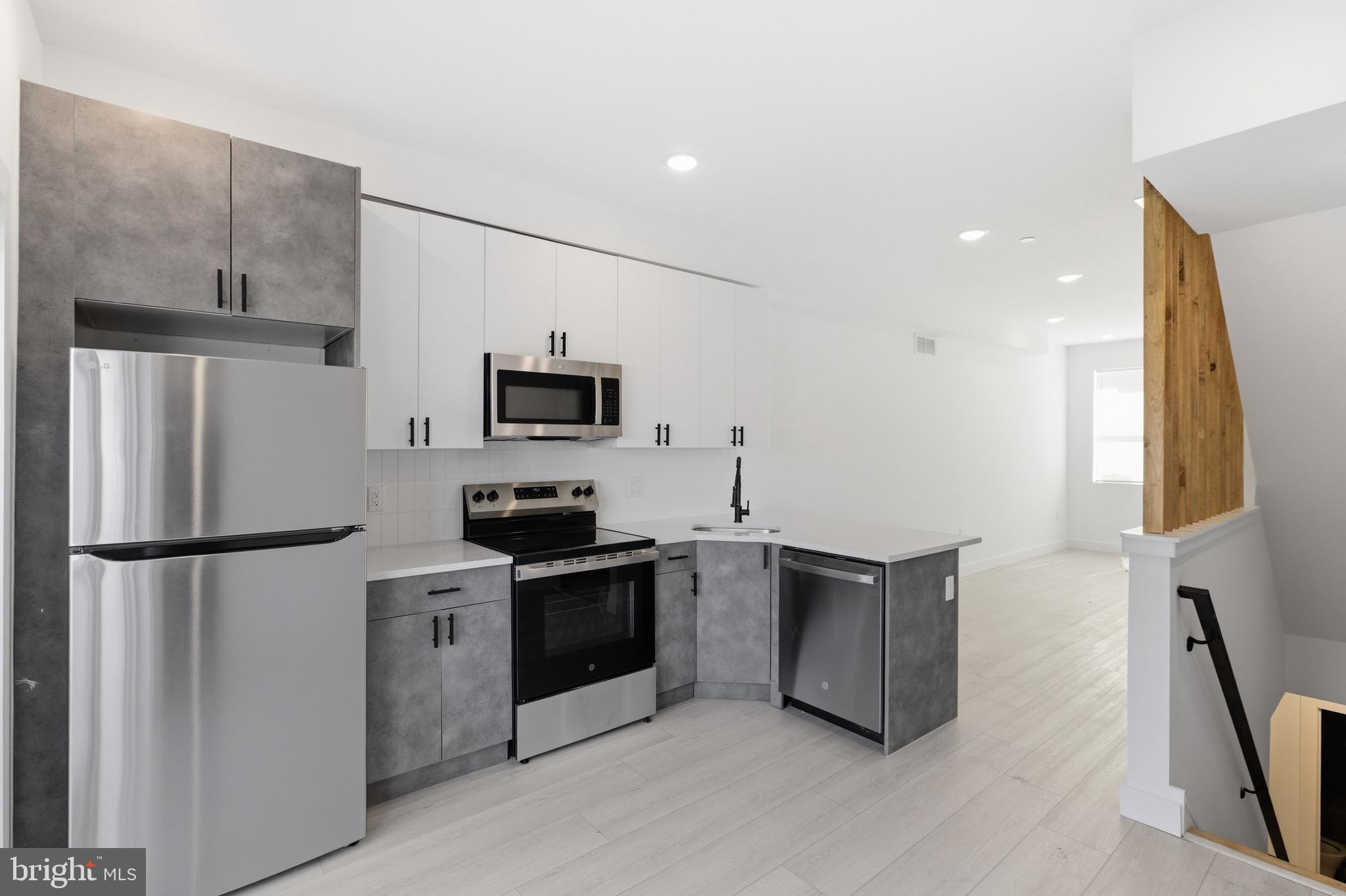 1005 West Orleans Street Philadelphia, PA 19133 - Photo 4 of 25 a kitchen with stainless steel appliances a refrigerator stove microwave and sink