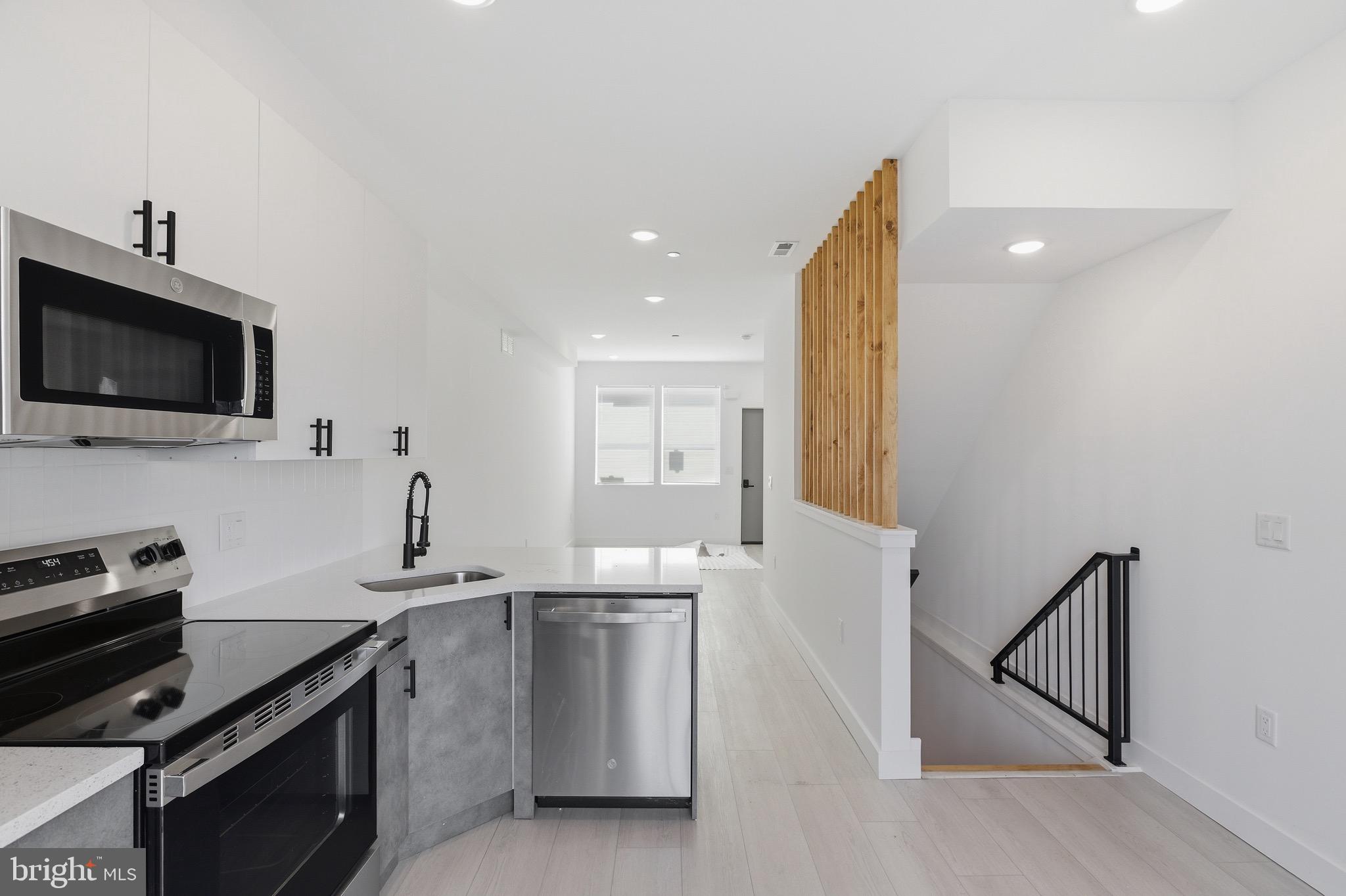 1005 West Orleans Street Philadelphia, PA 19133 - Photo 5 of 25 a kitchen with a sink stainless steel appliances and cabinets